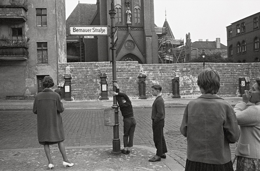 People in West Berlin look at an early version of the Berlin Wall